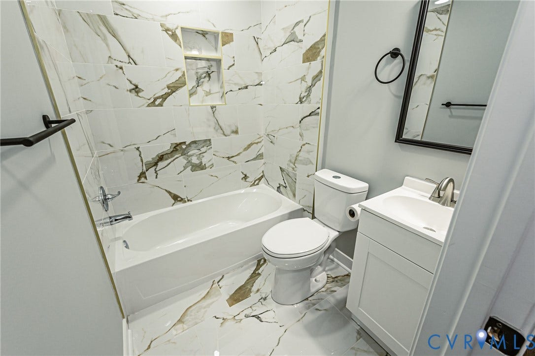 1608 Bryan Street, Richmond, VA 23223 Bathroom featuring a white vanity with integrated sink, a white bathtub, and a tile surround with an integrated niche