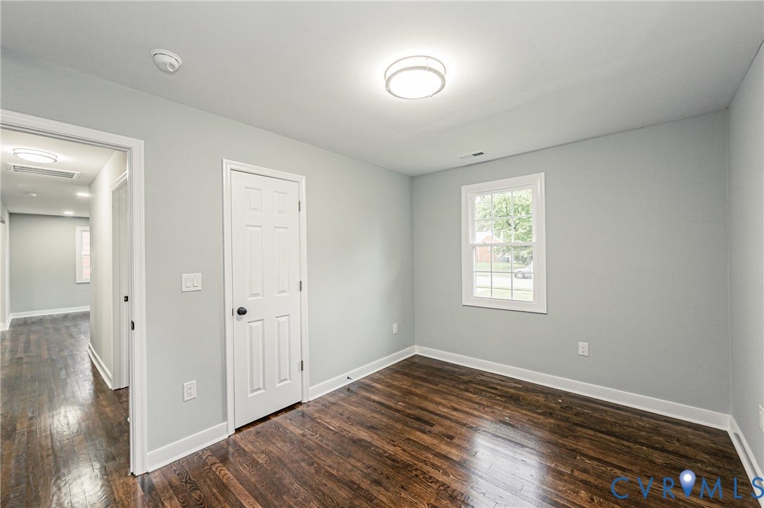 1608 Bryan Street, Richmond, VA 23223 Hardwood-finish flooring, light grey wall paint, a single window, a flush-mount ceiling light fixture, and white trim