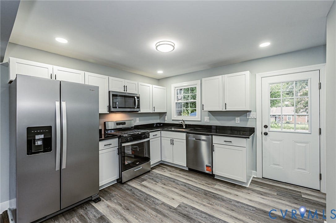 1608 Bryan Street, Richmond, VA 23223 Kitchen featuring wood-finish flooring, white cabinetry, dark countertops, and stainless steel appliances