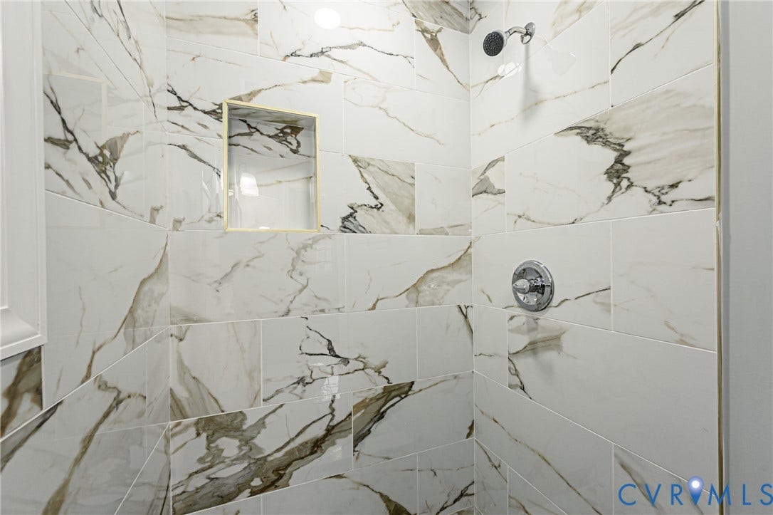 1608 Bryan Street, Richmond, VA 23223 Shower with white and gray veined tile, built-in recessed niche, chrome showerhead, and chrome control knob