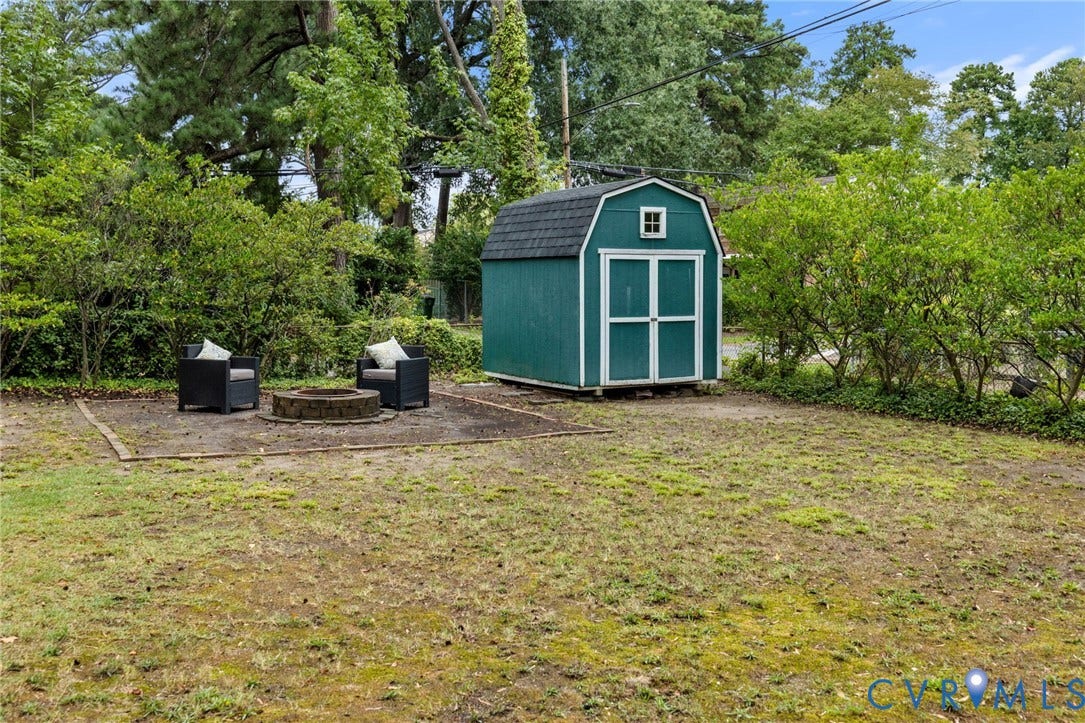 Green barn-style shed with a gambrel roof and white trim