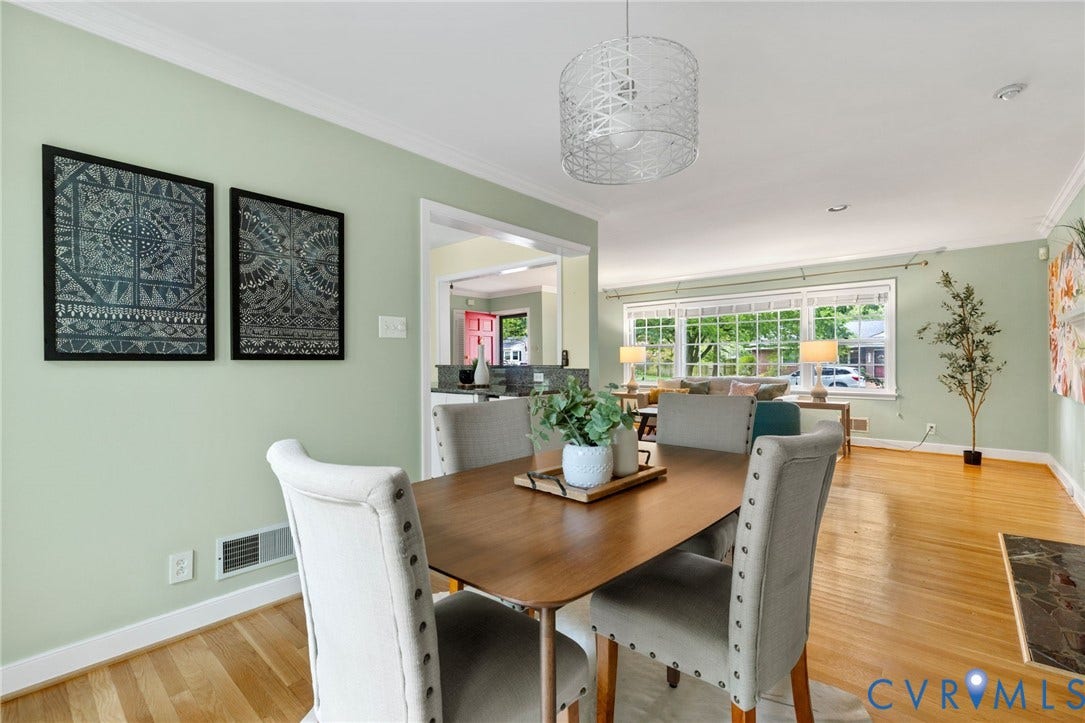 Hardwood flooring throughout, crown molding, and a modern drum pendant light fixture