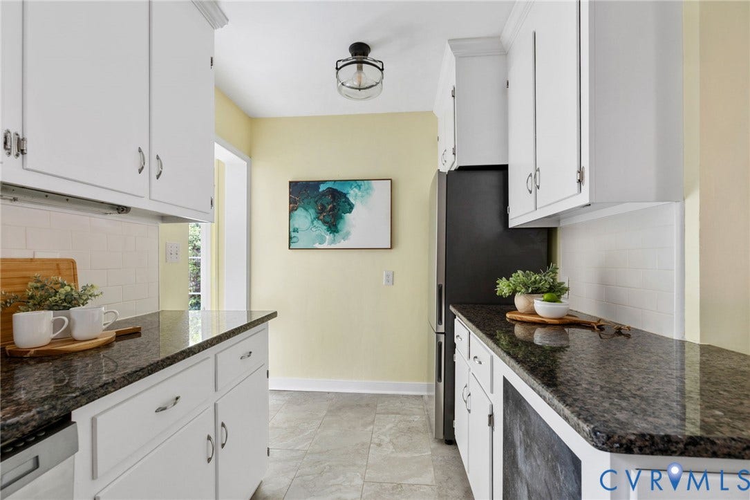 White cabinetry with polished hardware, dark stone countertops, subway tile backsplash, and a flush-mount light fixture