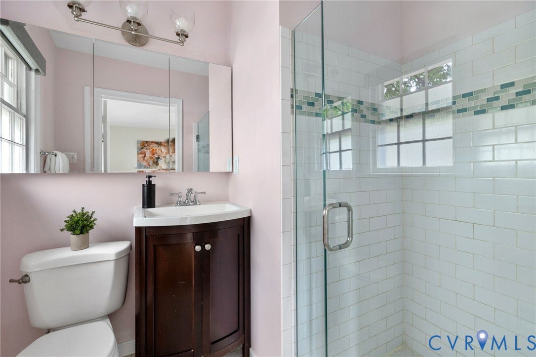 Glass-enclosed shower with subway tile surround and decorative accent band