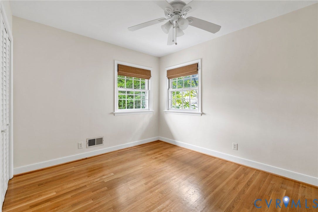 Wood-finish flooring, white trim, dual windows, and ceiling fan