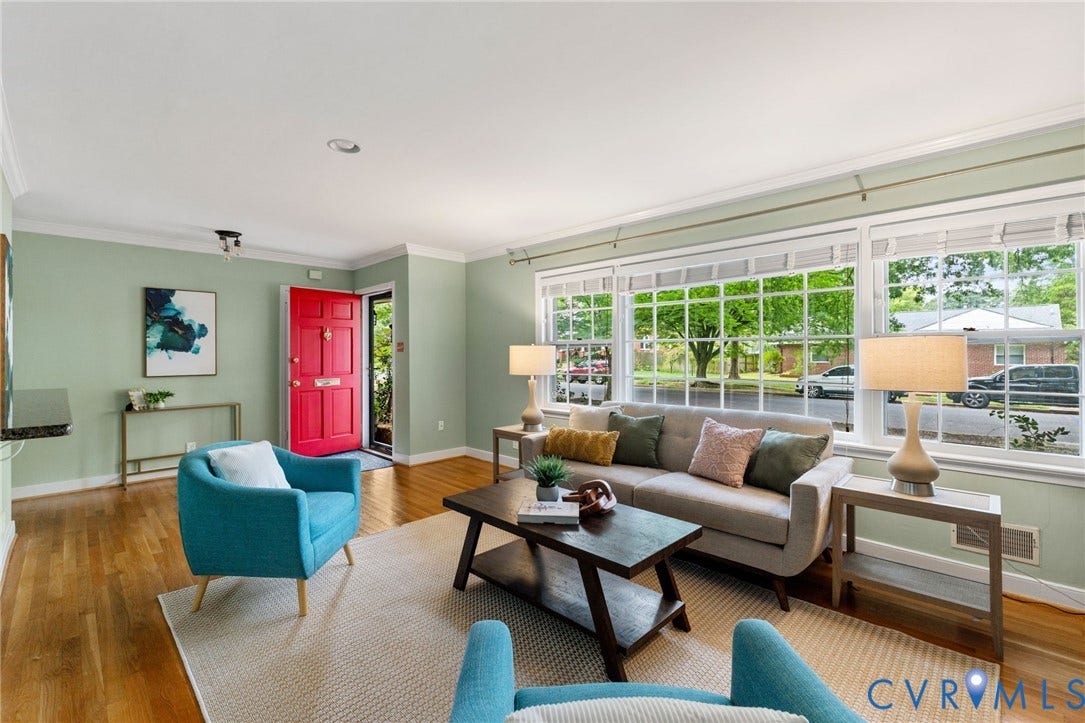 Hardwood-finish flooring, white crown molding, red-painted entry door, multiple pane windows, and recessed lighting