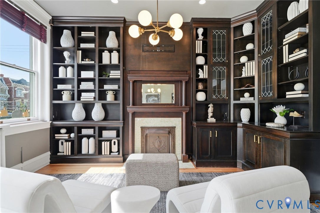 1848 W Grace Street, Historic W. Grace Street, Richmond, VA 23220 Built-in wood-finish shelving, an ornate fireplace with a mantel, and a multi-arm chandelier create a sophisticated ambiance