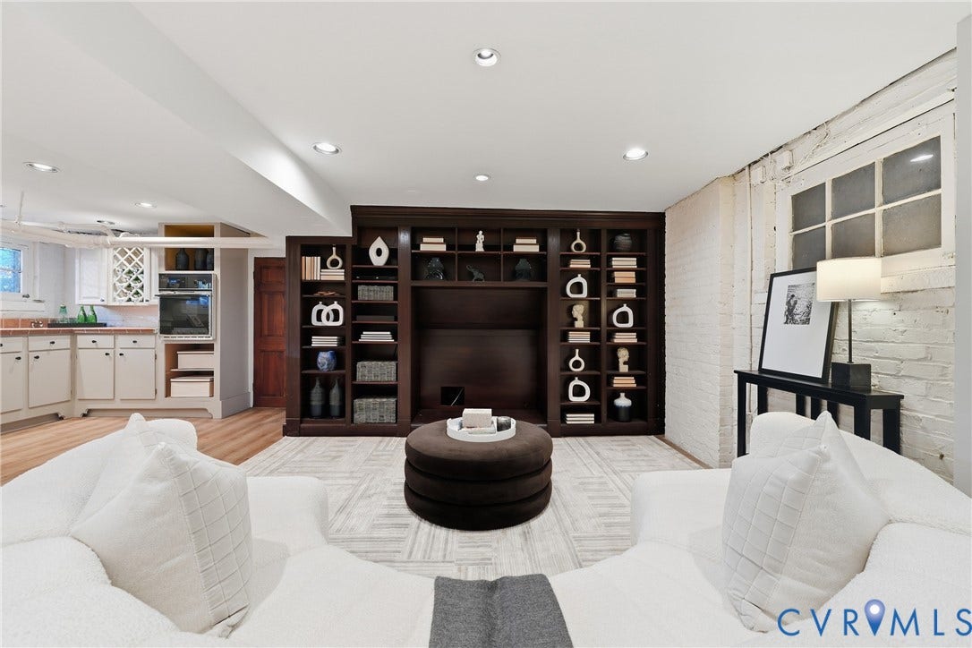 1848 W Grace Street, Historic W. Grace Street, Richmond, VA 23220 Recessed lighting, wood-finish flooring, built-in dark wood cabinetry with integrated shelving, a white painted brick wall, and a built-in kitchen area with white cabinetry