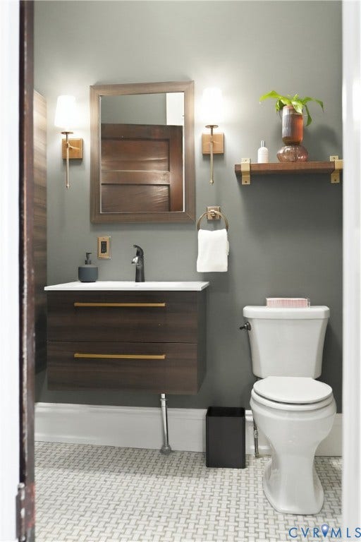 1848 W Grace Street, Historic W. Grace Street, Richmond, VA 23220 Floating wood-finish vanity with gold-tone hardware, white countertop, and dark-finish faucet