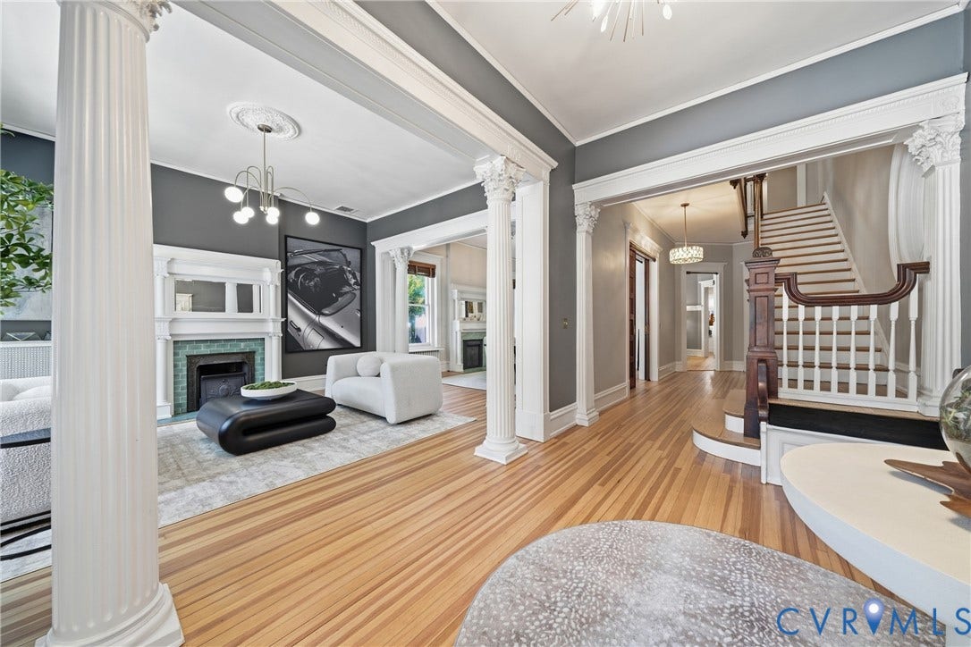1848 W Grace Street, Historic W. Grace Street, Richmond, VA 23220 Hardwood flooring throughout, decorative columns, grand staircase with wood newel post and balusters, fireplace with tile surround and white mantel, and ceiling medallion with chandelier