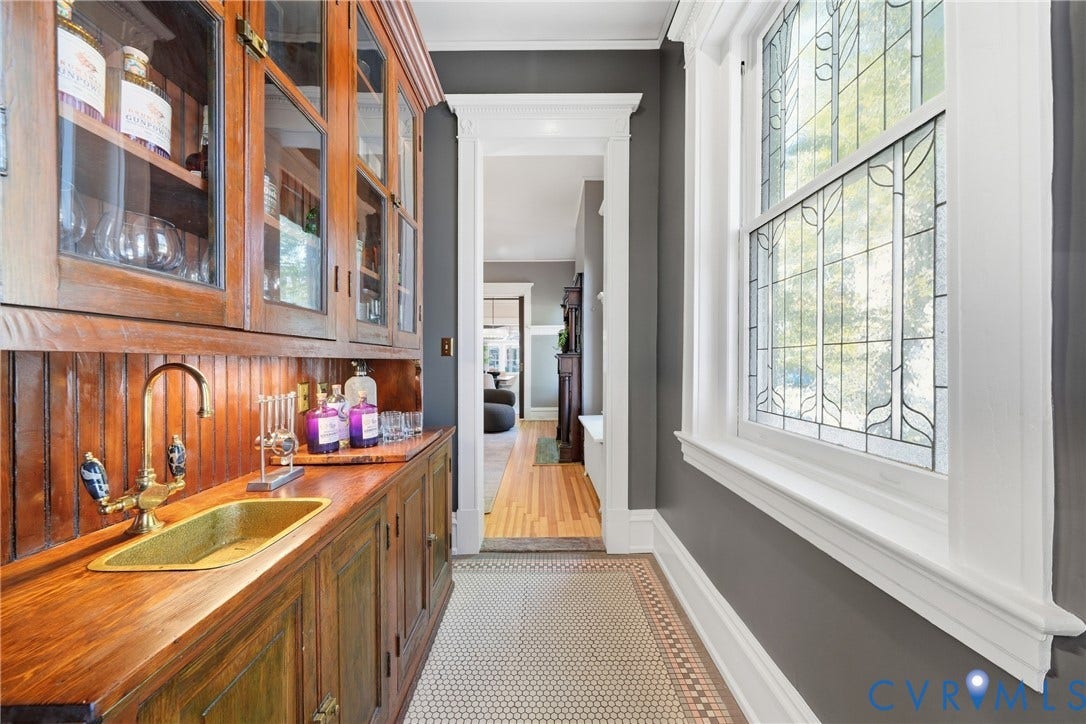 1848 W Grace Street, Historic W. Grace Street, Richmond, VA 23220 Built-in wooden cabinetry with glass-front uppers, brass faucet and sink, beadboard backsplash, leaded glass window, and hexagonal tile flooring