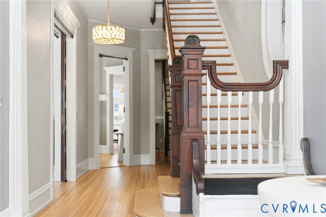 1848 W Grace Street, Historic W. Grace Street, Richmond, VA 23220 Hardwood flooring throughout, a grand wooden staircase with white risers, decorative newel post, and a contemporary drum pendant light fixture