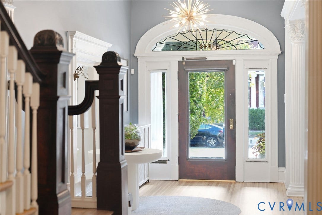 1848 W Grace Street, Historic W. Grace Street, Richmond, VA 23220 Hardwood flooring, dark wood newel posts, white balusters, decorative transom window, and a modern sputnik light fixture