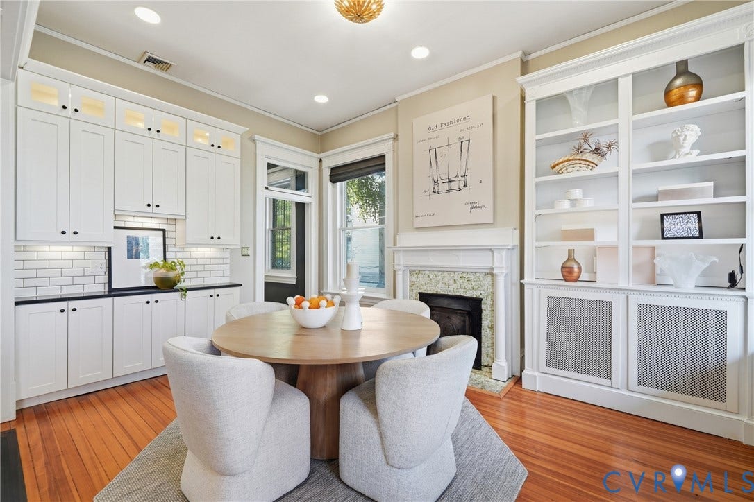 1848 W Grace Street, Historic W. Grace Street, Richmond, VA 23220 Hardwood flooring, built-in shelving, white cabinetry, subway tile backsplash, and a fireplace with a stone surround