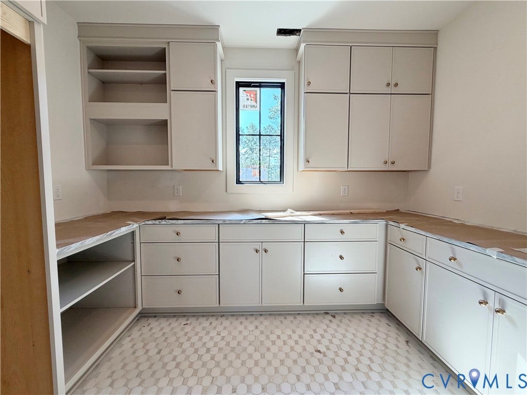 Extensive cabinetry with varied storage options, a built-in countertop, and a window for natural light