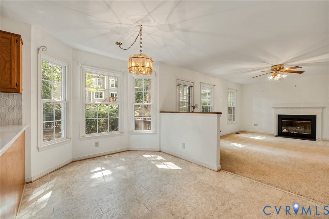 3005 Wiltonshire Drive, Richmond, VA 23233 Bay window with multiple windows, patterned tile flooring, built-in fireplace with white mantel, ceiling fan, and wood cabinetry
