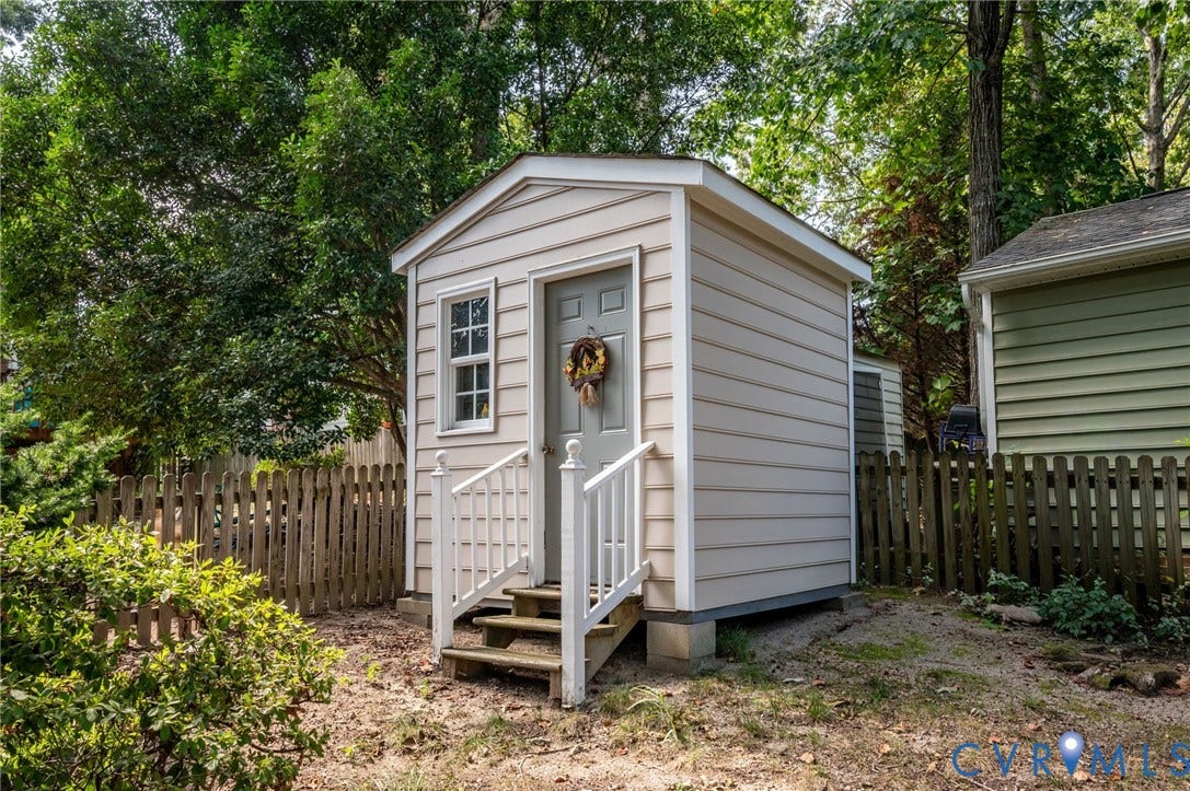 3005 Wiltonshire Drive, Richmond, VA 23233 Detached storage shed with horizontal siding, small-pane window, and a wood picket fence