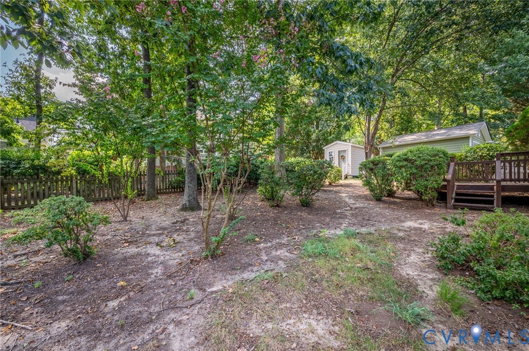 3005 Wiltonshire Drive, Richmond, VA 23233 Expansive backyard with a wood privacy fence, mature trees, a detached storage shed, and a wood-finish deck