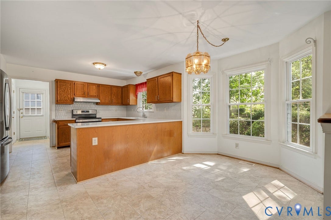 3005 Wiltonshire Drive, Richmond, VA 23233 Kitchen featuring a breakfast bar, wood cabinetry, stainless steel appliances, and a tiled backsplash