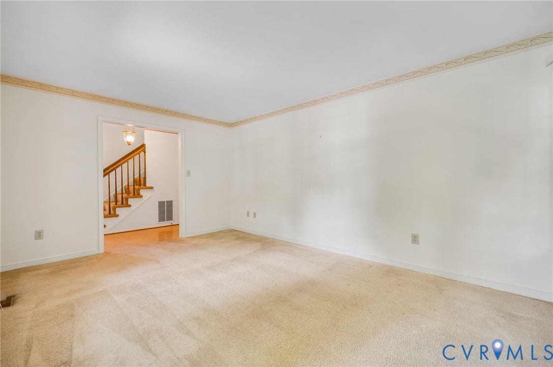 3005 Wiltonshire Drive, Richmond, VA 23233 Carpeted room with a wide doorway to a foyer featuring wood-finish flooring and a staircase with a wood handrail