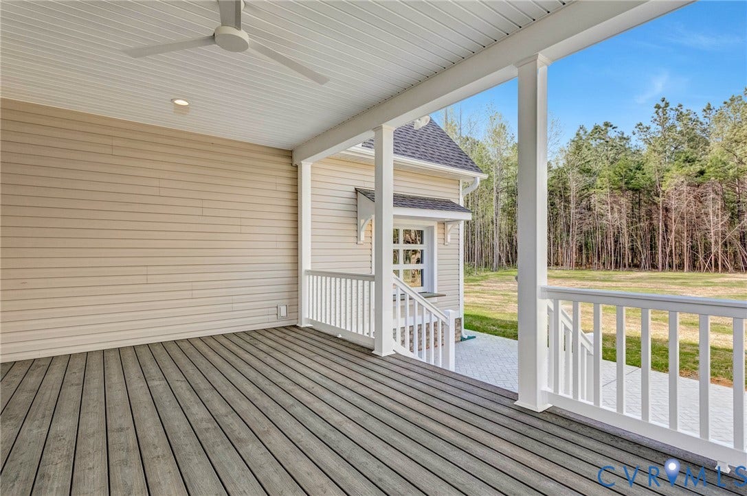 The property features a covered porch with plank decking and a ceiling fan, offering views of the surrounding natural landscape