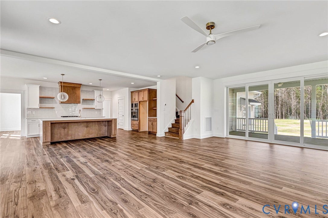 Open concept living area featuring wood floors, recessed lighting, and a modern ceiling fan