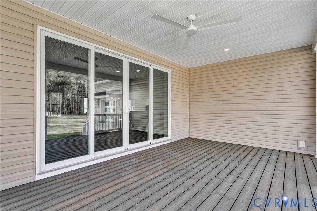 Covered outdoor deck with a ceiling fan, recessed lighting, and sliding glass doors