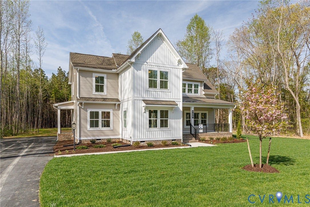 This property features a two-story exterior with a mix of light-colored siding and vertical white board and batten siding