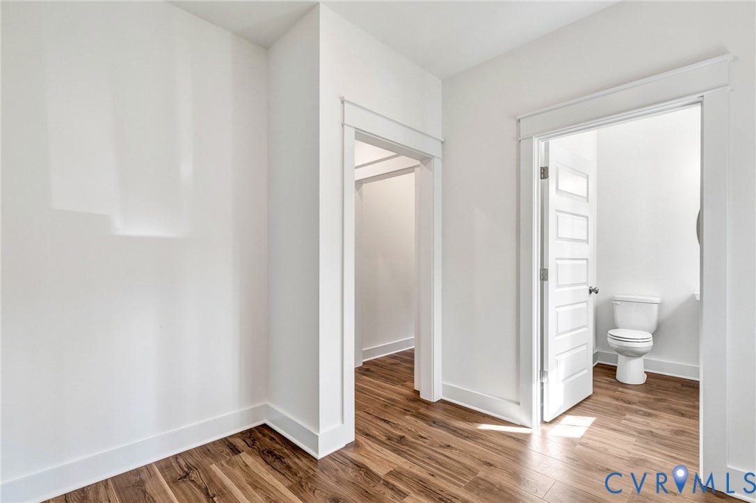 The property features warm-toned wood flooring, crisp white walls, and bright white trim
