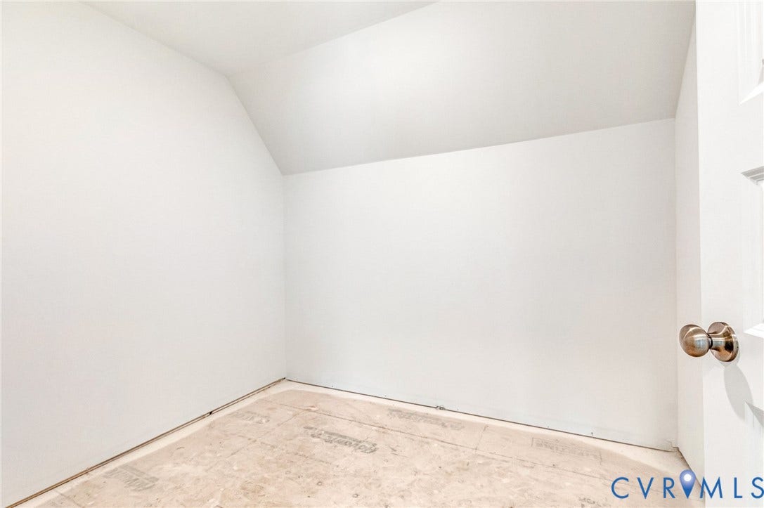 The property offers a room with pristine white walls and an angled ceiling, awaiting custom flooring