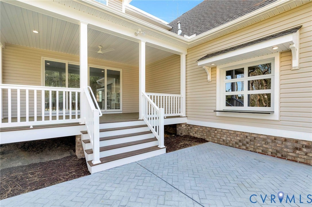 The property features an outdoor patio area with a paved surface and brick detailing along the exterior wall