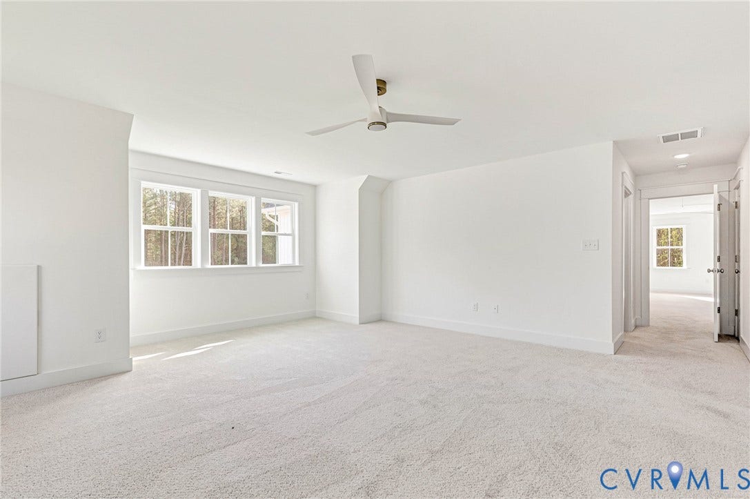 Bright room featuring white walls and light-colored carpet