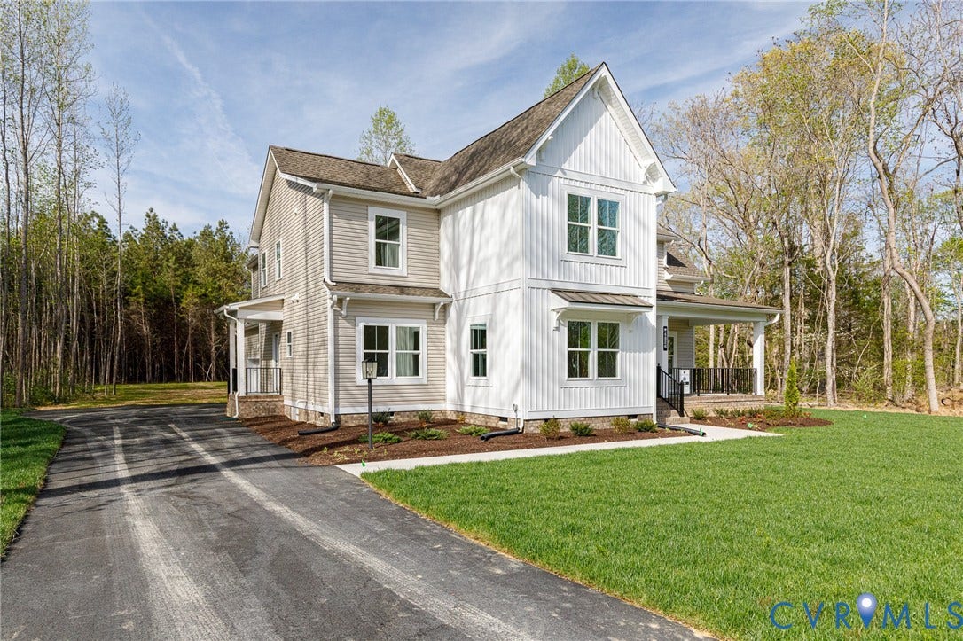 The property features a two-story exterior with light-colored siding and a covered porch