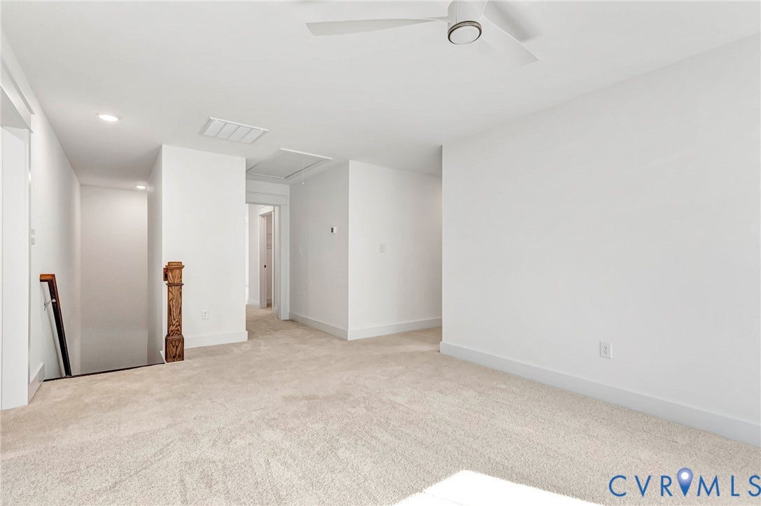 Open area featuring neutral carpet, white walls, and a ceiling fan