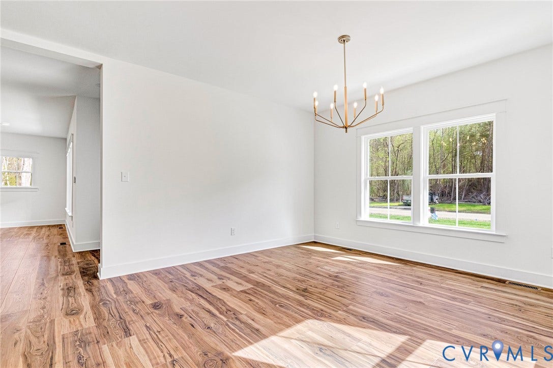 The property features hardwood flooring, white walls, and a modern chandelier