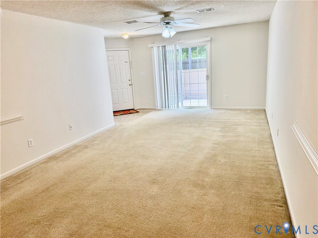 Soft carpeting, ceiling fan with light fixture, white interior door, sliding glass door, and a private outdoor space