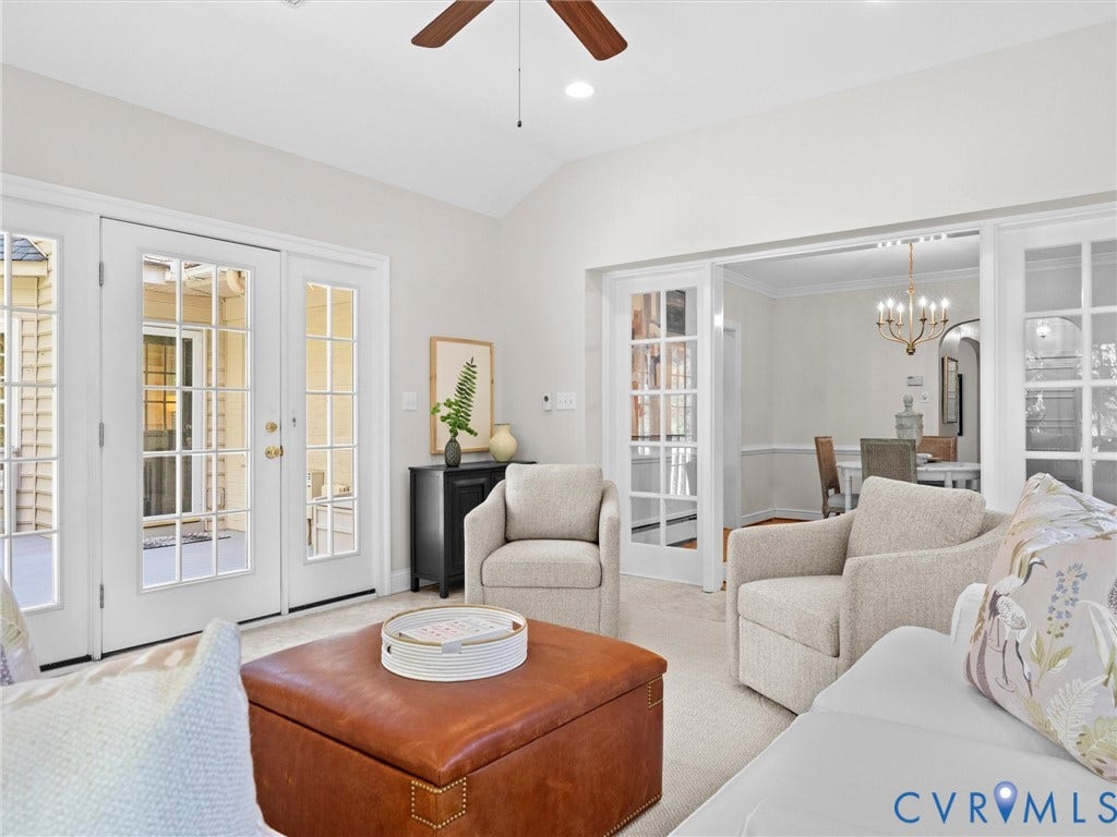 216 Ross Road, Westham Area, Henrico, VA 23229 Bright, light-filled primary living space showcasing French doors with multiple glass panes opening to outdoor spaces, ceiling fan with recessed lighting, neutral wall finishes, and wood-finish flooring throughout