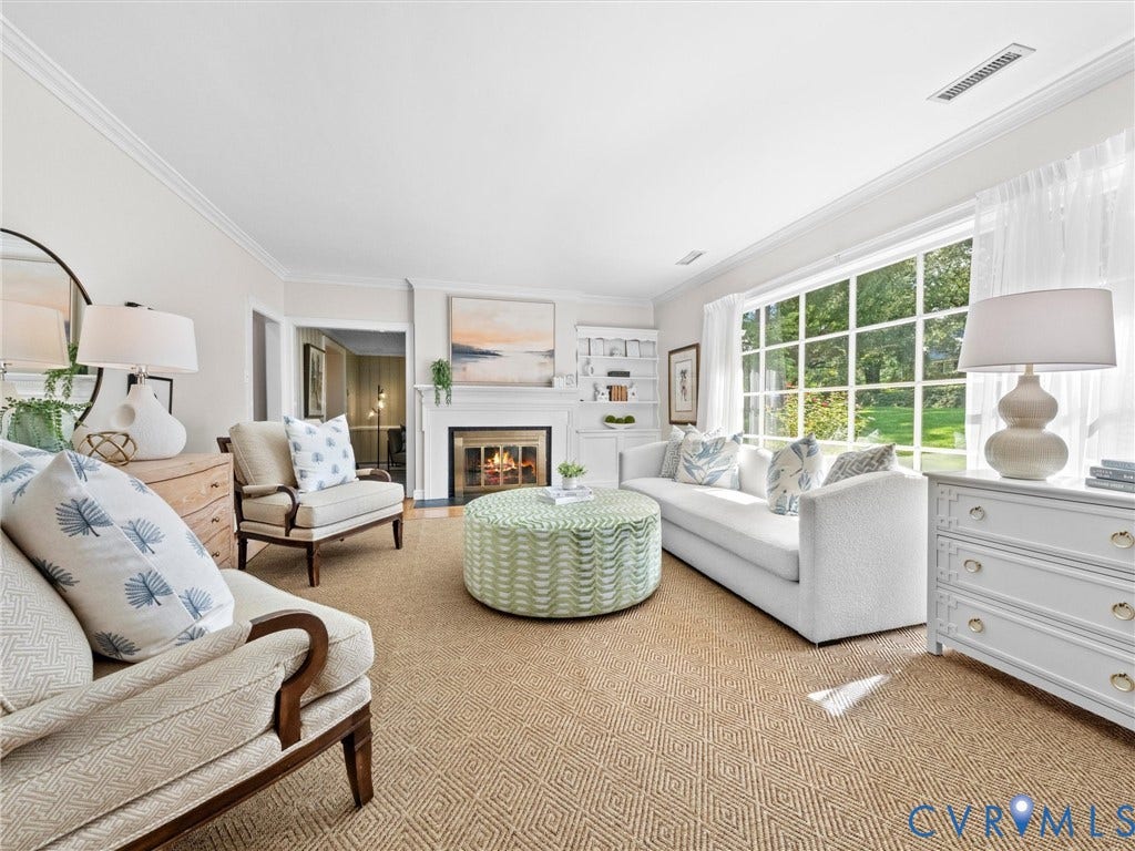 216 Ross Road, Westham Area, Henrico, VA 23229 Gas fireplace with a white mantel, built-in shelving, large picture window, crown molding, and patterned carpet flooring