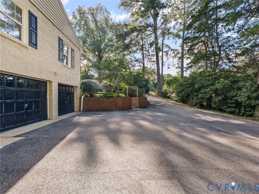 216 Ross Road, Westham Area, Henrico, VA 23229 Light-colored brick exterior with black shutters and two garage bays