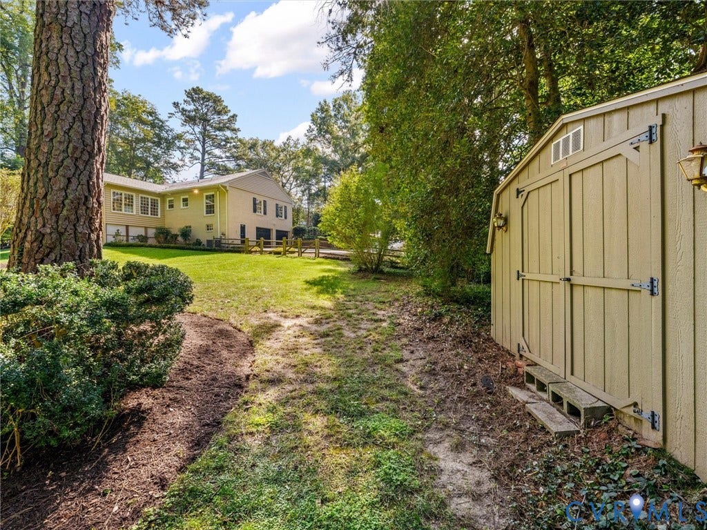 216 Ross Road, Westham Area, Henrico, VA 23229 Expansive backyard with a manicured lawn, established trees, and a detached storage shed
