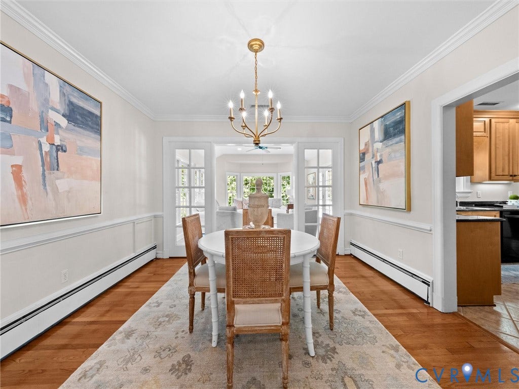 216 Ross Road, Westham Area, Henrico, VA 23229 Elegant formal dining room showcasing hardwood flooring, wainscoting detail, and brass chandelier