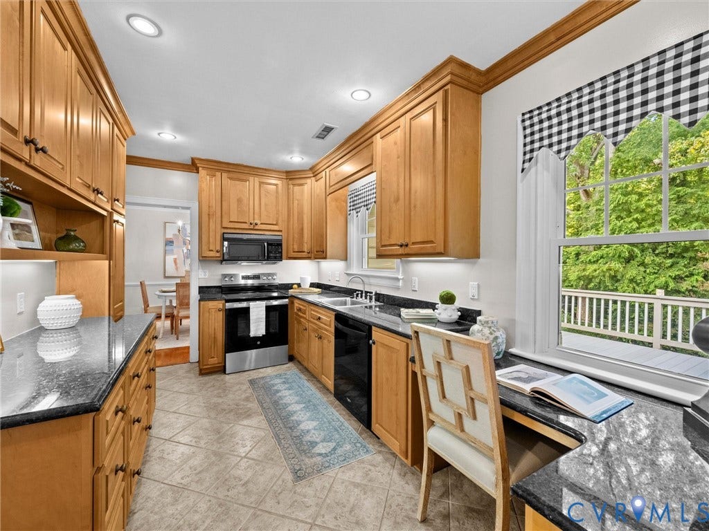 216 Ross Road, Westham Area, Henrico, VA 23229 Kitchen featuring extensive wood cabinetry, dark countertops, tile flooring, and integrated stainless steel and black appliances