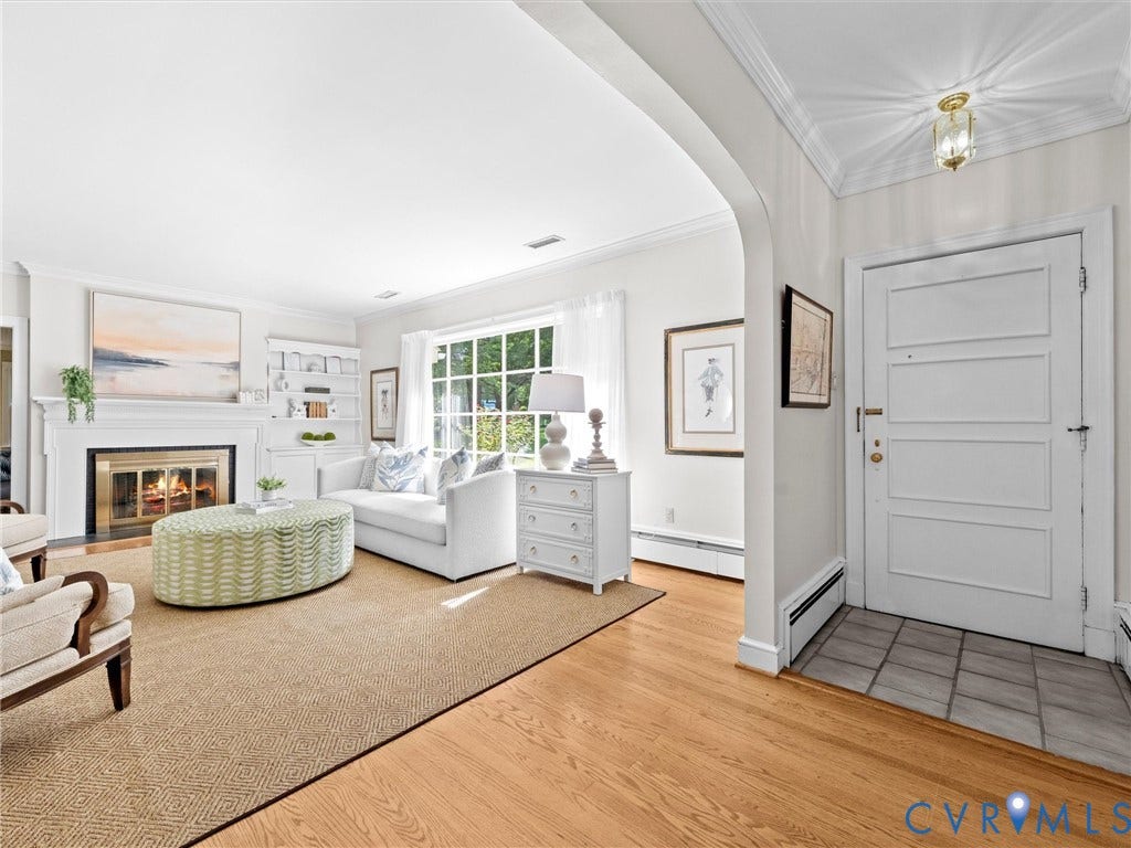 216 Ross Road, Westham Area, Henrico, VA 23229 Living room featuring a fireplace with a white mantel, built-in shelving, large window with grid panes, and wood-finish flooring