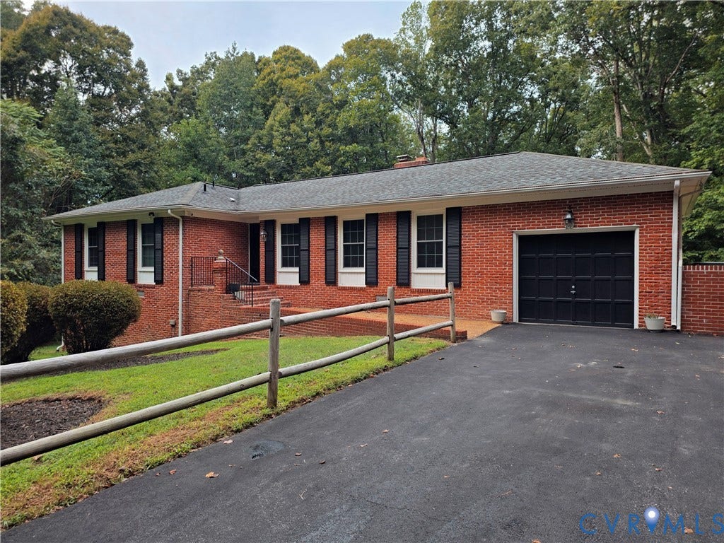 Brick exterior with black shutters and a black garage door