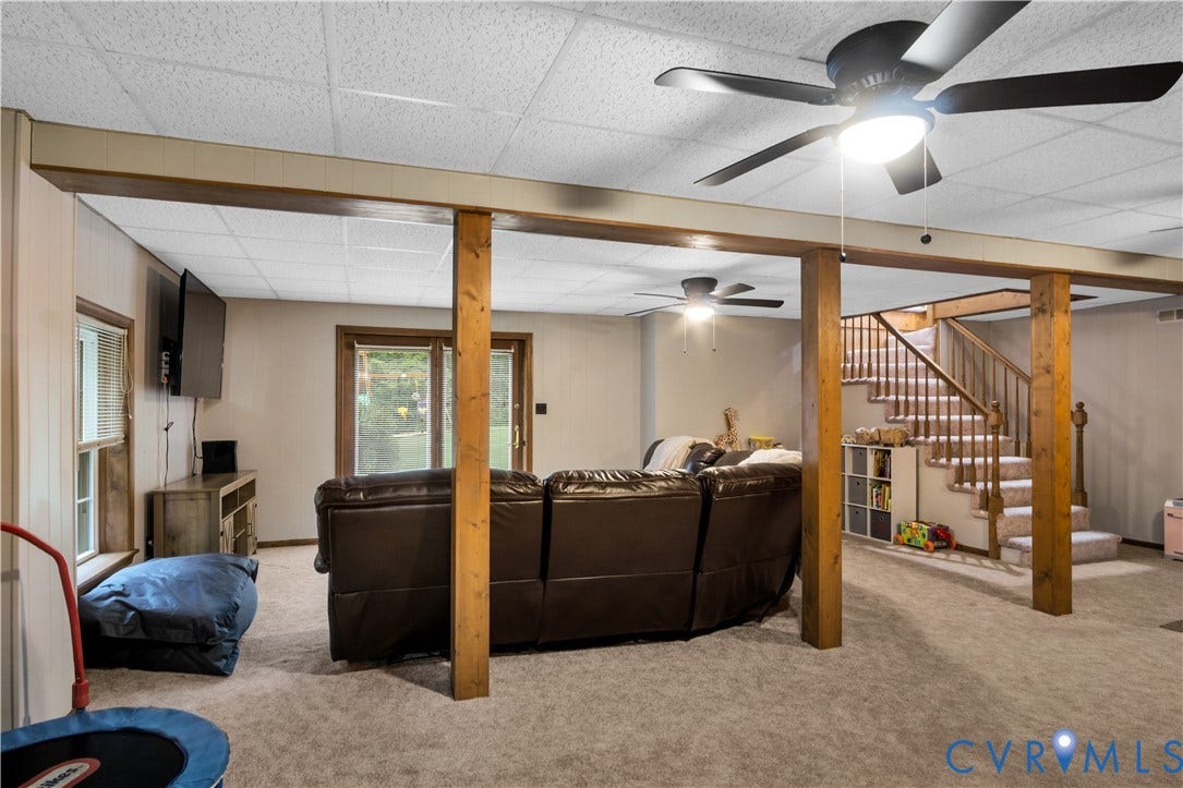 Carpeted living area with wood-finish structural beams and columns
