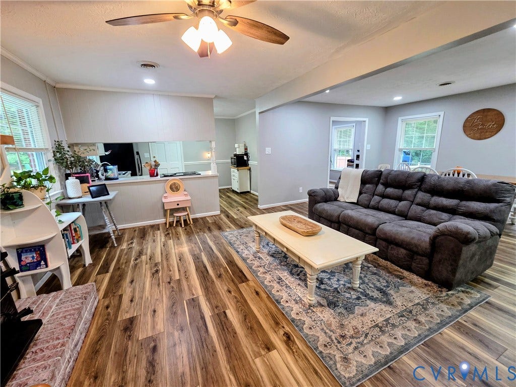 Open-concept living area featuring wood-finish flooring, recessed lighting, and a ceiling fan