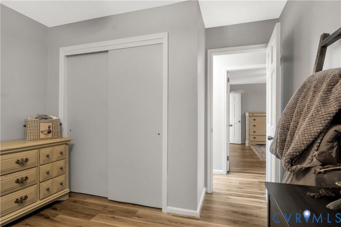 Wood-finish flooring throughout, white trim, and light gray wall paint