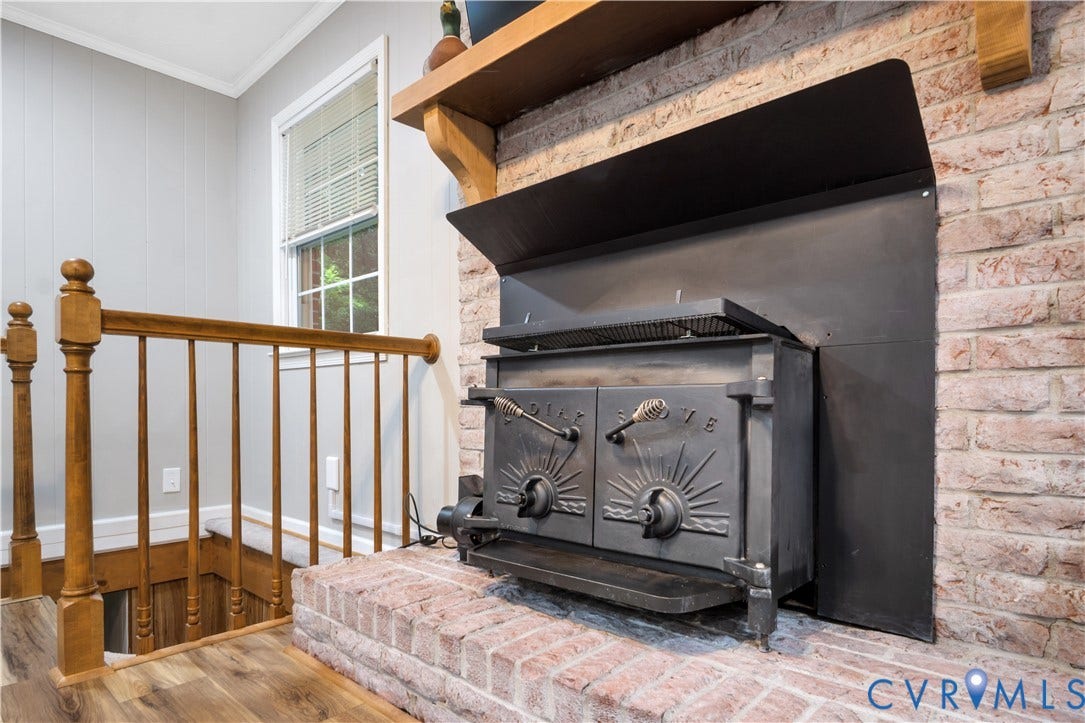 Brick fireplace with a built-in wood-burning stove and a wood mantel