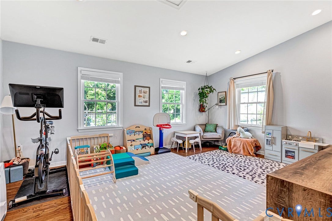 Recessed ceiling lighting, wood-finish flooring, light gray wall paint, multiple windows, and white trim