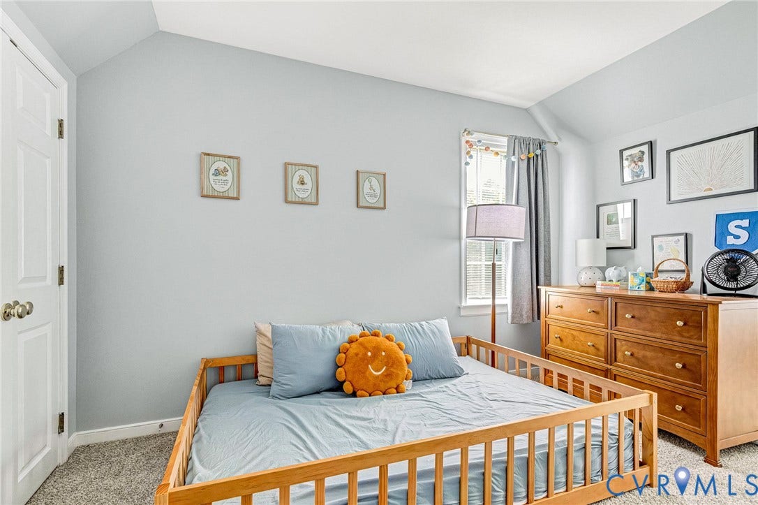 Carpeted flooring, vaulted ceiling, and white trim